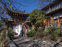 a building with several chinese archways above the gate that leads up to it and a stream below