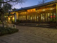 the outside of a chinese building with some lights on at dusk's time or night