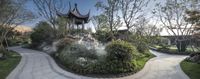 the chinese garden at the asian house features a gazebo and many plants and trees