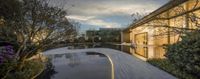 a stone path leading to a pool and an office building that appears to be designed to reflect the sky