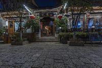 the entrance to a chinese restaurant with lanterns in front of it, at night time