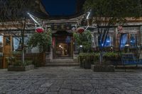 the entrance to a chinese restaurant with lanterns in front of it, at night time