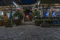 the entrance to a chinese restaurant with lanterns in front of it, at night time