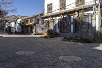 a street with stone walls lined in chinese writing and flowers and vines around the windows