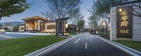 a chinese village with lush green grass and a sidewalk in front of the building has a sign that reads