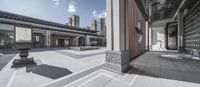 a courtyard that has tables and benches in it and a clock at the top of the building