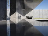 a sculpture sitting on top of a reflecting pool in an empty building next to another water feature