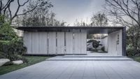 an outdoor house that is built in a garden with trees, bushes and rocks outside