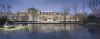 a beautiful house with a glass enclosed courtyard and outdoor water feature at night time taken in a city