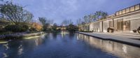 a beautiful house with a glass enclosed courtyard and outdoor water feature at night time taken in a city