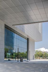 a white building with a lot of windows in front of it on a sunny day