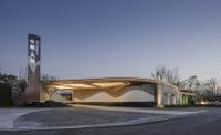 the large building has a curved roof and signage outside of it's entrance area