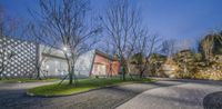 the exterior of the new cultural center in china is shown at dusk with green lawn