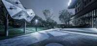 an upside down umbrella stands on concrete with trees and grass in the background at night