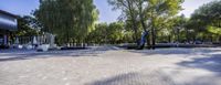 there is a park with trees, benches and water features and benches at the edges