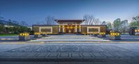 a pavilion sits in the middle of a park at dusk, where lights are lit up