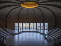 a big circular auditorium with stairs to the top of it and people walking around the bottom of the seating area