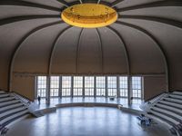 a big circular auditorium with stairs to the top of it and people walking around the bottom of the seating area