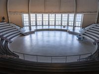 a big circular auditorium with stairs to the top of it and people walking around the bottom of the seating area