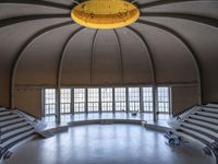 a big circular auditorium with stairs to the top of it and people walking around the bottom of the seating area