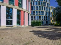 a circular building with colorful glass windows and doors in front of it and the reflection of its own