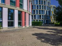 a circular building with colorful glass windows and doors in front of it and the reflection of its own