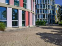 a circular building with colorful glass windows and doors in front of it and the reflection of its own