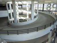 a circular ride in a parking garage surrounded by lots of cars on it's track