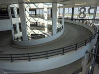 a circular ride in a parking garage surrounded by lots of cars on it's track