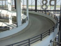 a circular ride in a parking garage surrounded by lots of cars on it's track