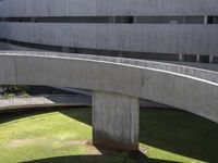 circular walkways at an architecturally designed concrete building, leading to several parking bays