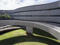 circular walkways at an architecturally designed concrete building, leading to several parking bays