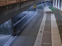 a long tunnel overpass that spans a street with traffic underneath it in a city setting