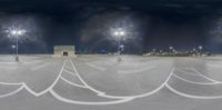 several large white arrows drawn into the cement in the dark sky above a airport terminal at night