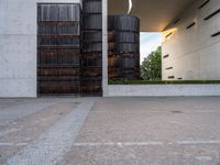 two tall dark brown metal tanks sitting next to a building with windows on top of each