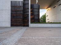 two tall dark brown metal tanks sitting next to a building with windows on top of each