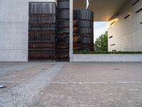 two tall dark brown metal tanks sitting next to a building with windows on top of each