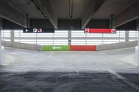 the parking garage with painted walls and painted arrows points to different directions on either side