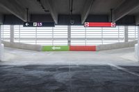 the parking garage with painted walls and painted arrows points to different directions on either side