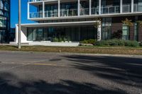 a man is riding his motorcycle down the road in front of a building with a balcony on it