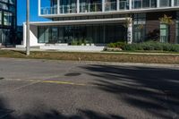 a man is riding his motorcycle down the road in front of a building with a balcony on it