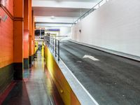 an empty long hallway with lots of parking and a sign in the middle of the space