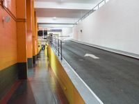 an empty long hallway with lots of parking and a sign in the middle of the space