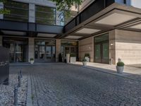 an outside view of a building with plants and rocks in the courtyard area, and a sign that says, i'll see you next