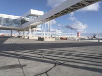 an airport with a jetliner and other airplanes in the sky behind a tall white structure