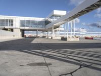 an airport with a jetliner and other airplanes in the sky behind a tall white structure