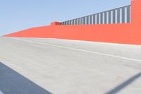 an empty parking lot and the road is orange, blue, white, and gray