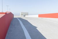 an empty parking lot and the road is orange, blue, white, and gray