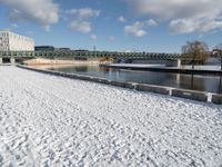 a white winter with a bridge and benches in front of it in the snow on the banks