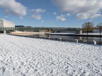 a white winter with a bridge and benches in front of it in the snow on the banks